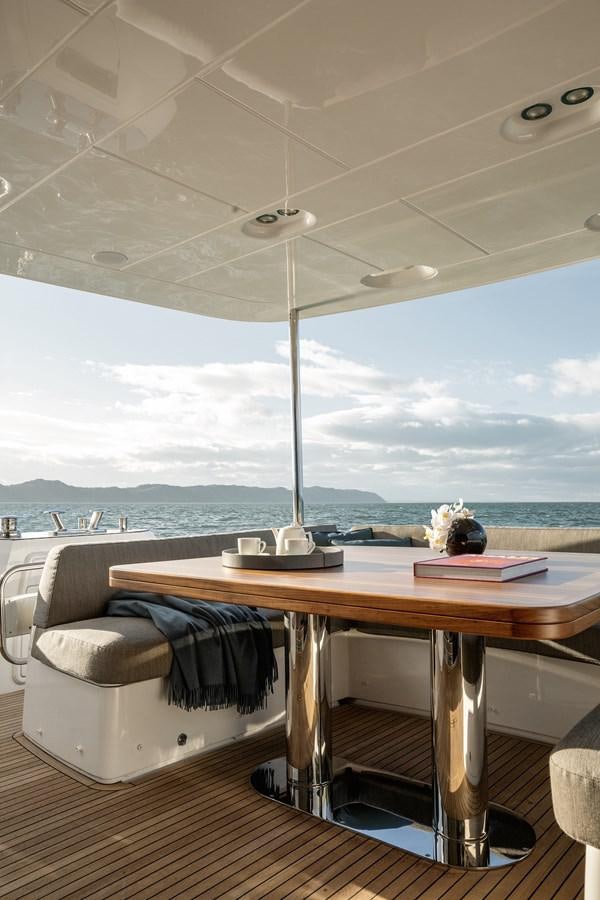 a table with a chair and a view of the water aboard 66 MAGELLANO Yacht for Sale