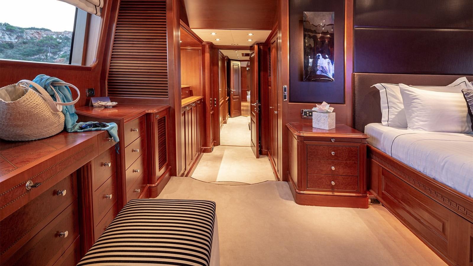 a bedroom with a bed and dresser aboard RIVA I Yacht for Sale