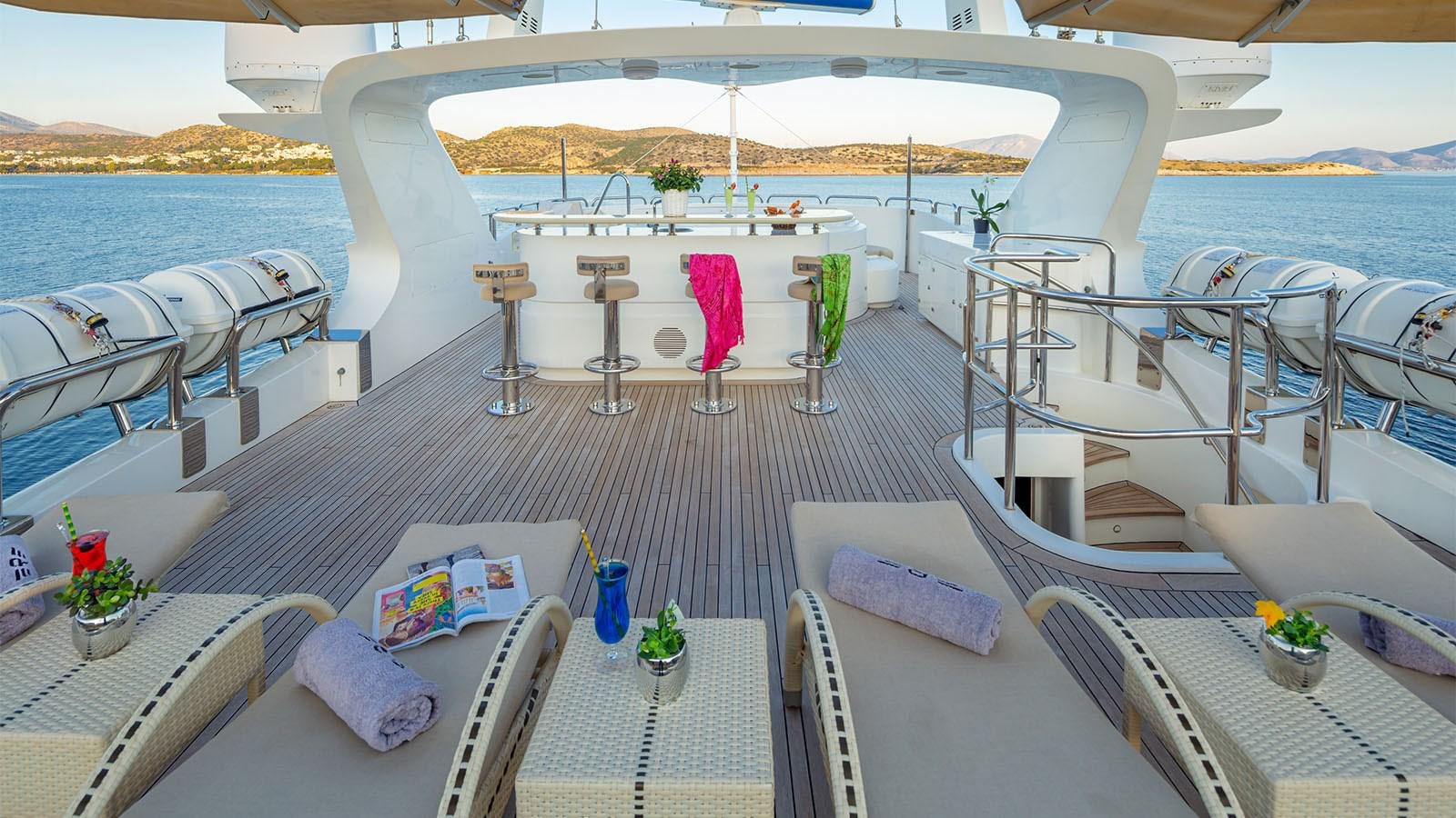a deck with a table and chairs aboard RIVA I Yacht for Sale