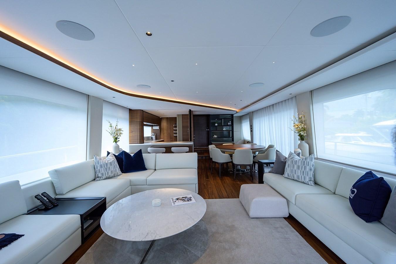 a living room with white furniture aboard ESCAPE Yacht for Sale