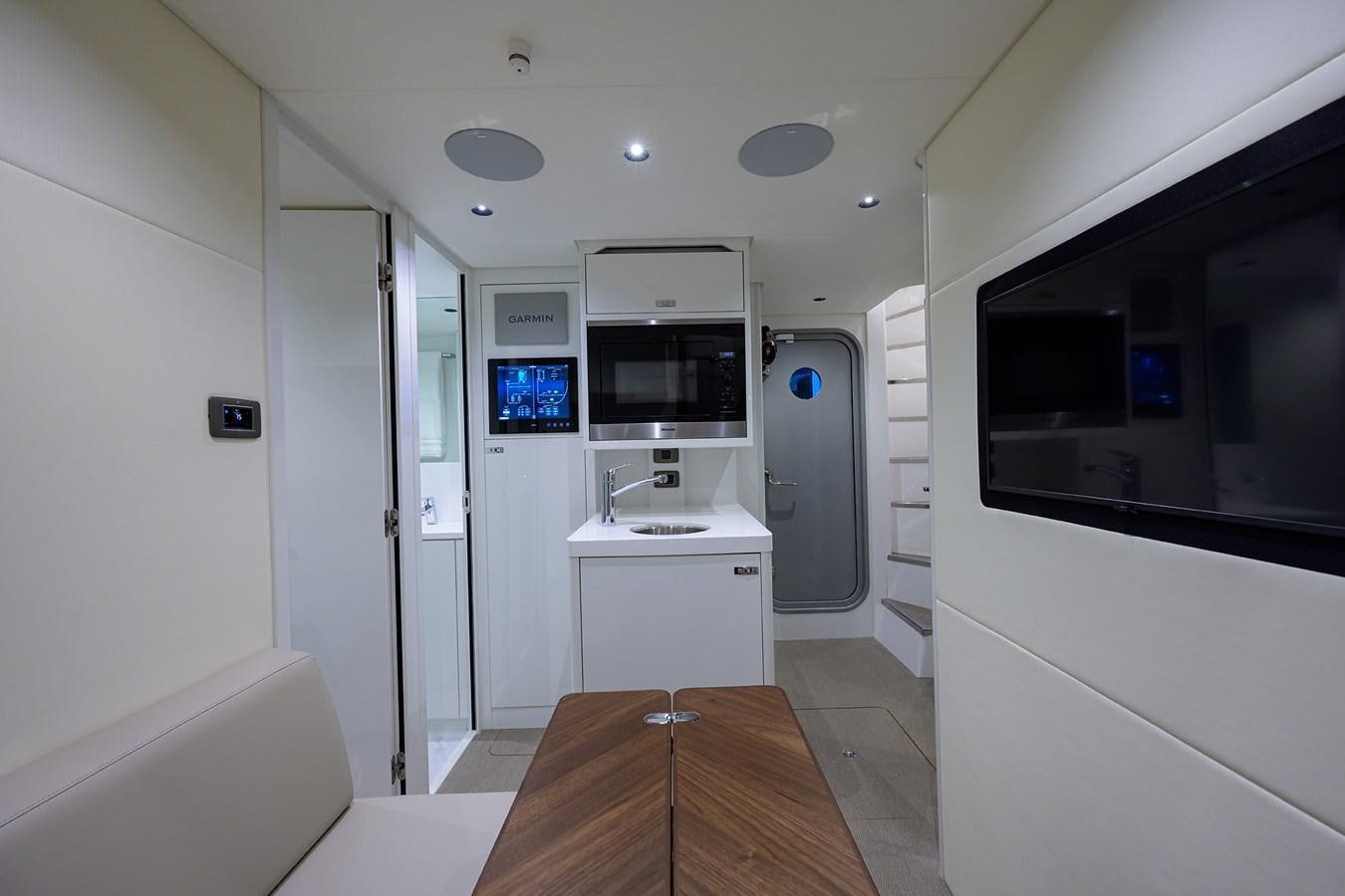a room with a table and a tv aboard ESCAPE Yacht for Sale