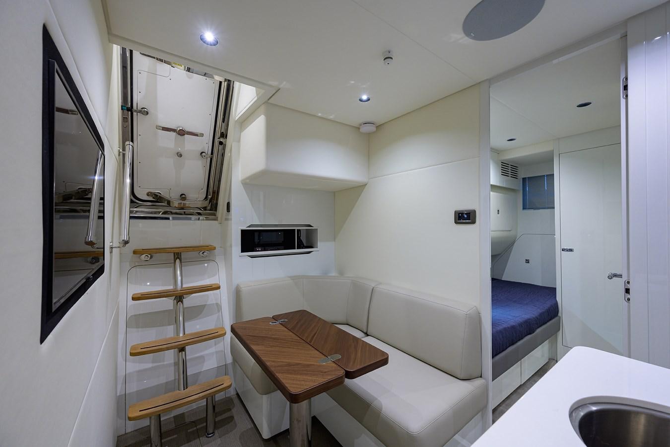 a modern looking room with a bed and a desk aboard ESCAPE Yacht for Sale