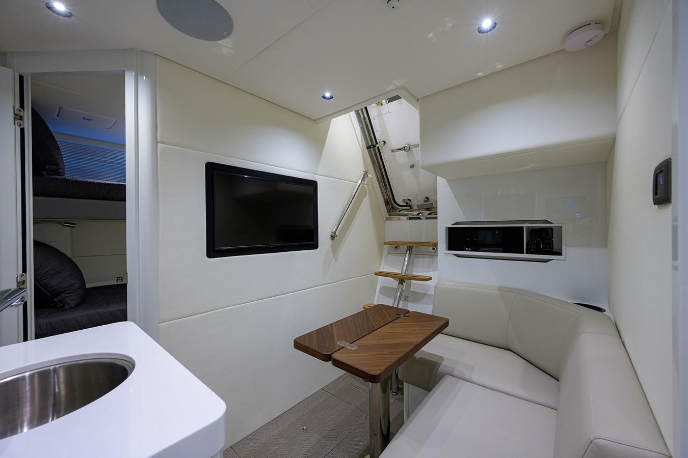 a small living room with a small table and tv aboard ESCAPE Yacht for Sale