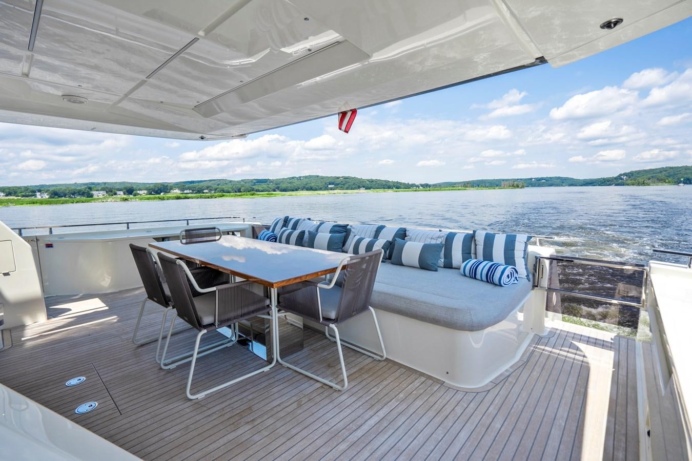 a table and chairs on a deck overlooking a body of water aboard PINCH ME Yacht for Sale