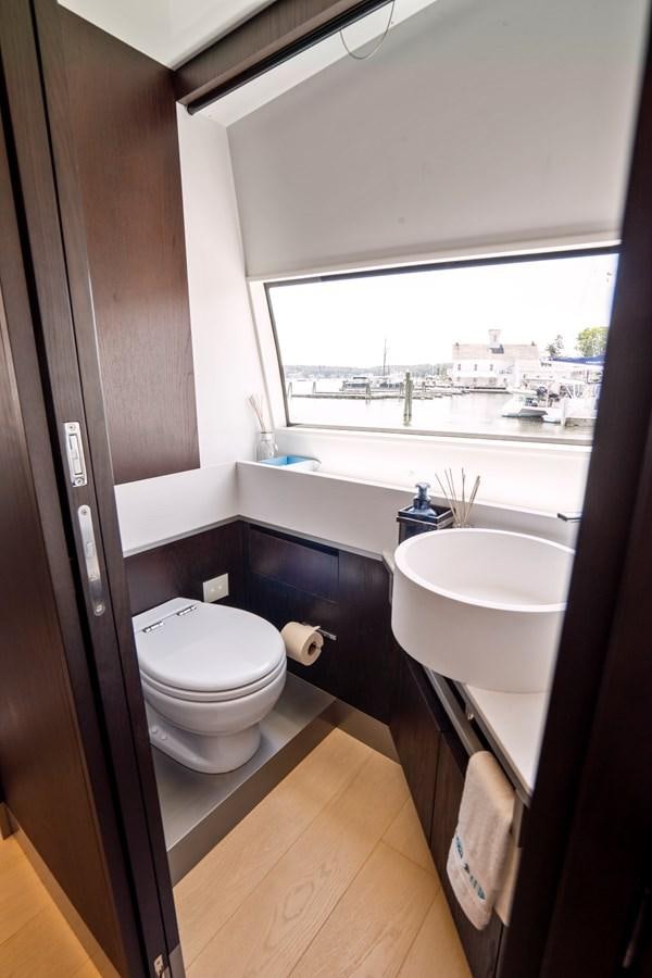 a bathroom with a sink toilet and a window aboard PINCH ME Yacht for Sale