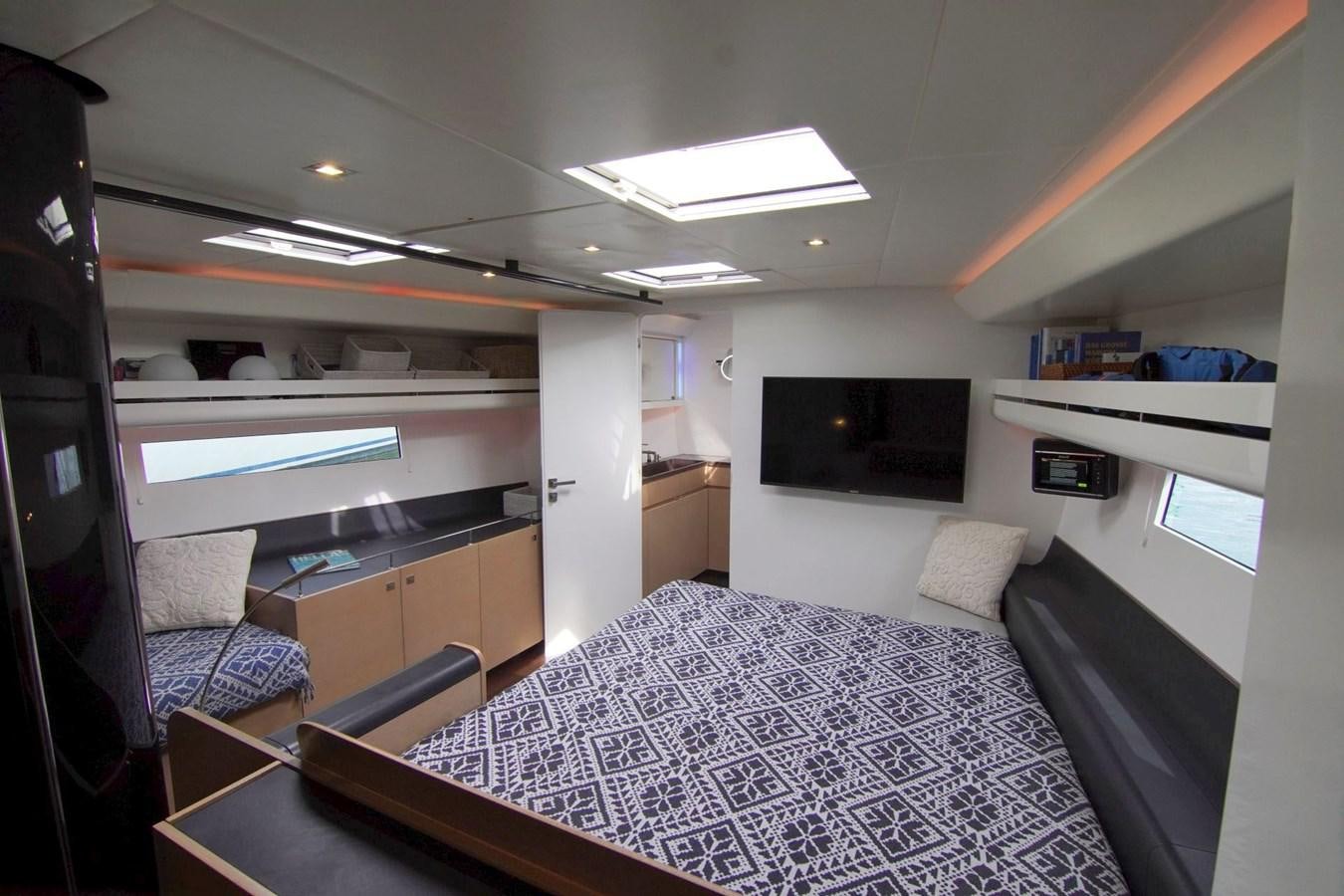 a bedroom with a bed and a tv aboard NYUMBA Yacht for Sale