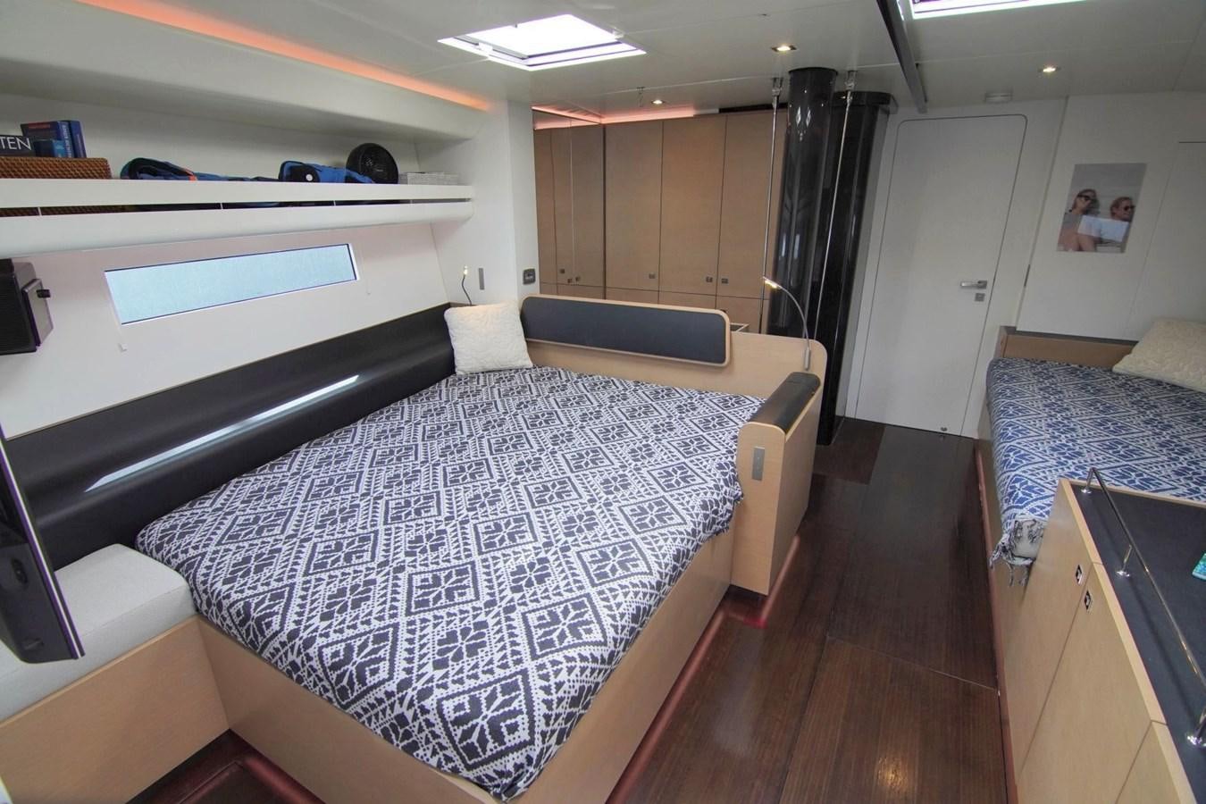 a room with a bed and a desk aboard NYUMBA Yacht for Sale