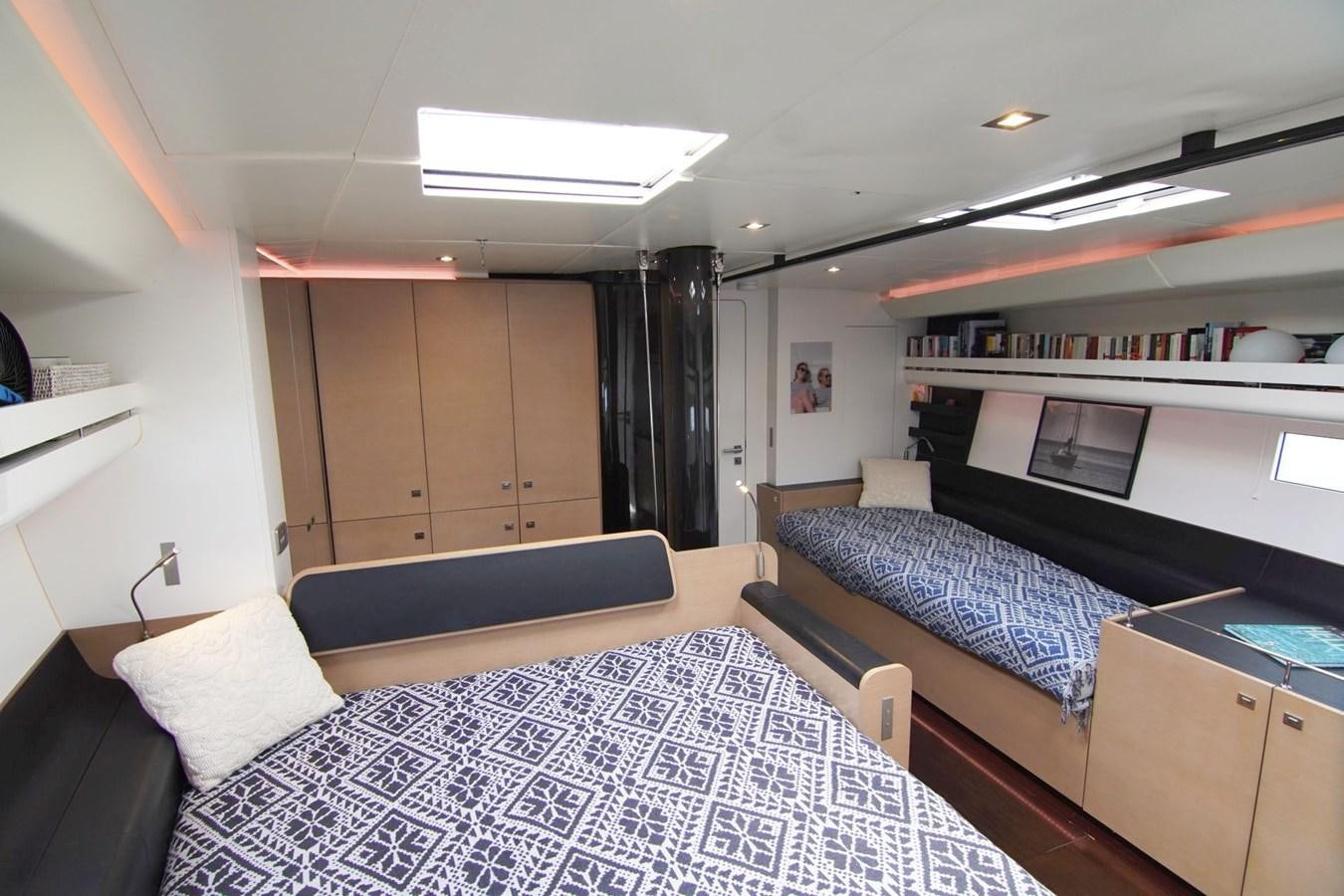 a bedroom with a bed and a desk aboard NYUMBA Yacht for Sale