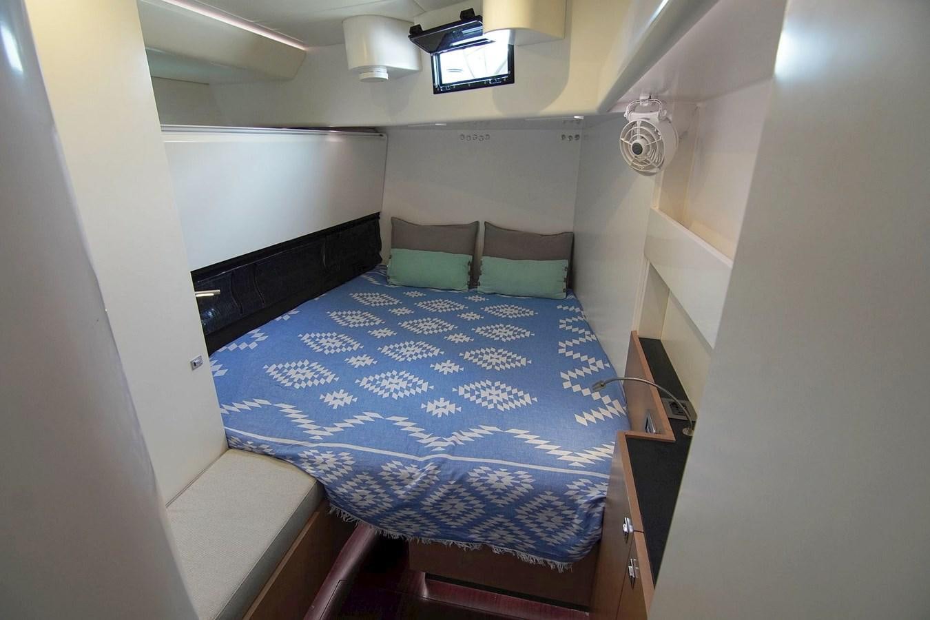 a bed with blue sheets aboard NYUMBA Yacht for Sale