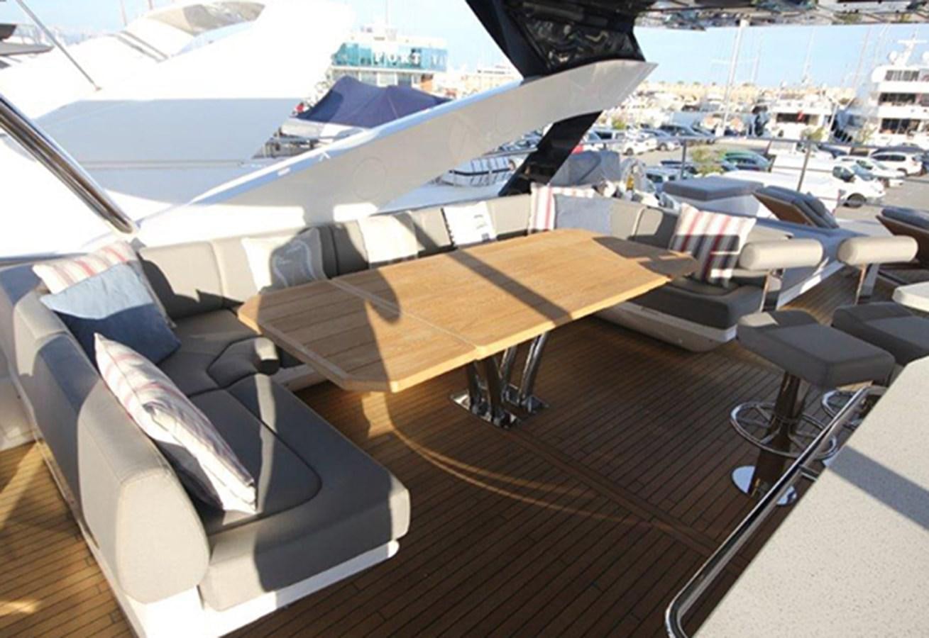 a deck with a table and chairs aboard MIBOWT Yacht for Sale