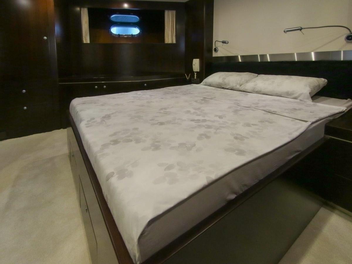 a bed with white sheets aboard POCO LOCO Yacht for Sale