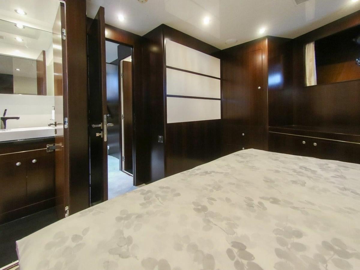 a large room with a large white bed and a large mirror aboard POCO LOCO Yacht for Sale