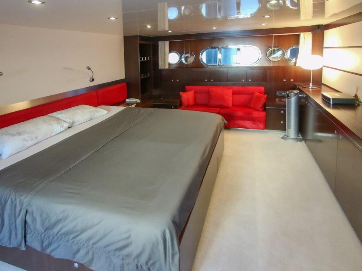 a room with a bed and a couch aboard POCO LOCO Yacht for Sale