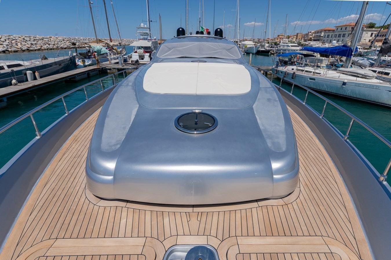 a deck with a convertible car on it and boats in the background aboard APHRODITE Yacht for Sale