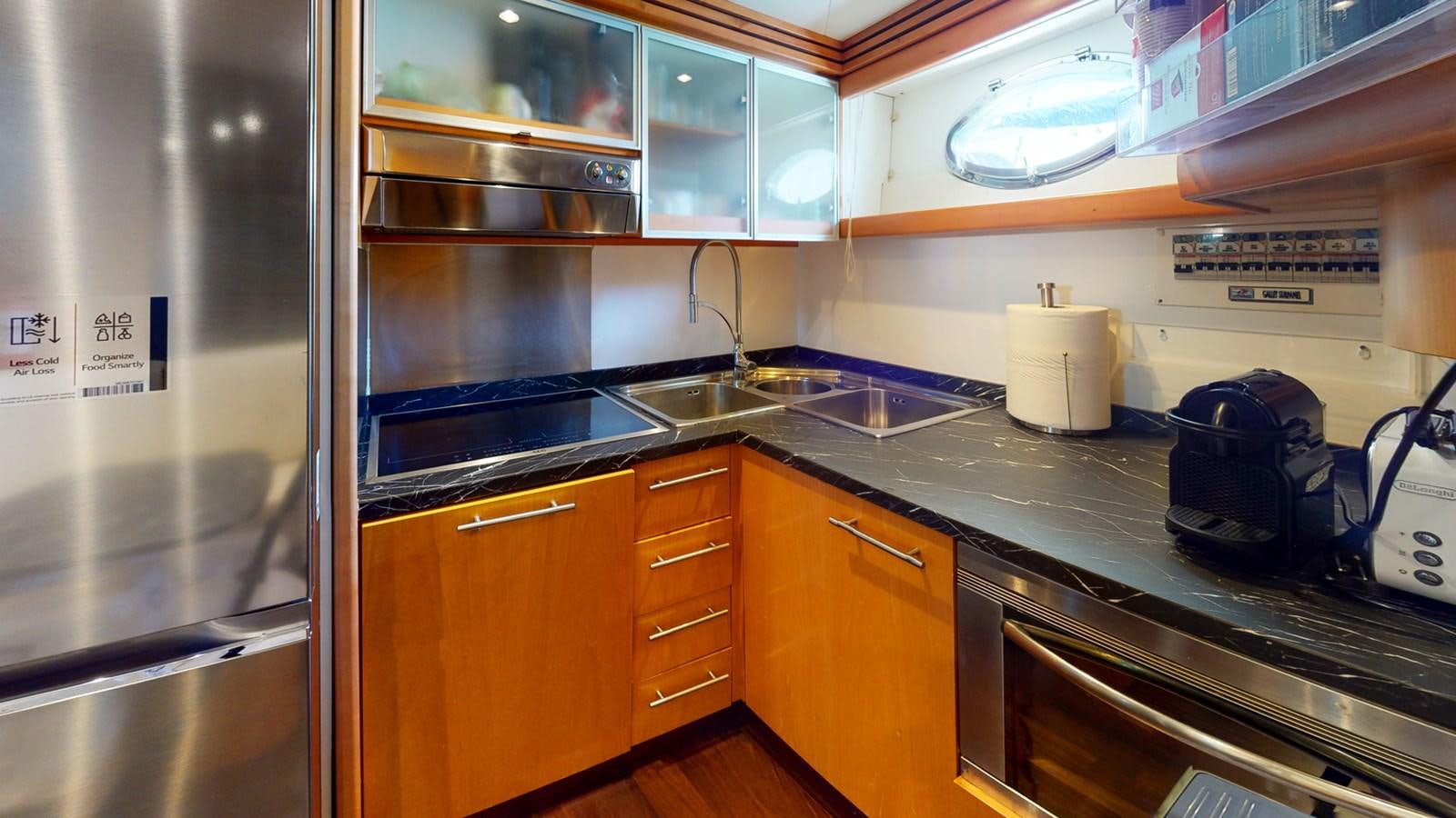 a kitchen with a stainless steel refrigerator aboard APHRODITE Yacht for Sale