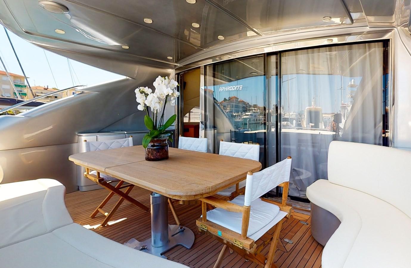 a table with chairs and a plant in a room with a window aboard APHRODITE Yacht for Sale
