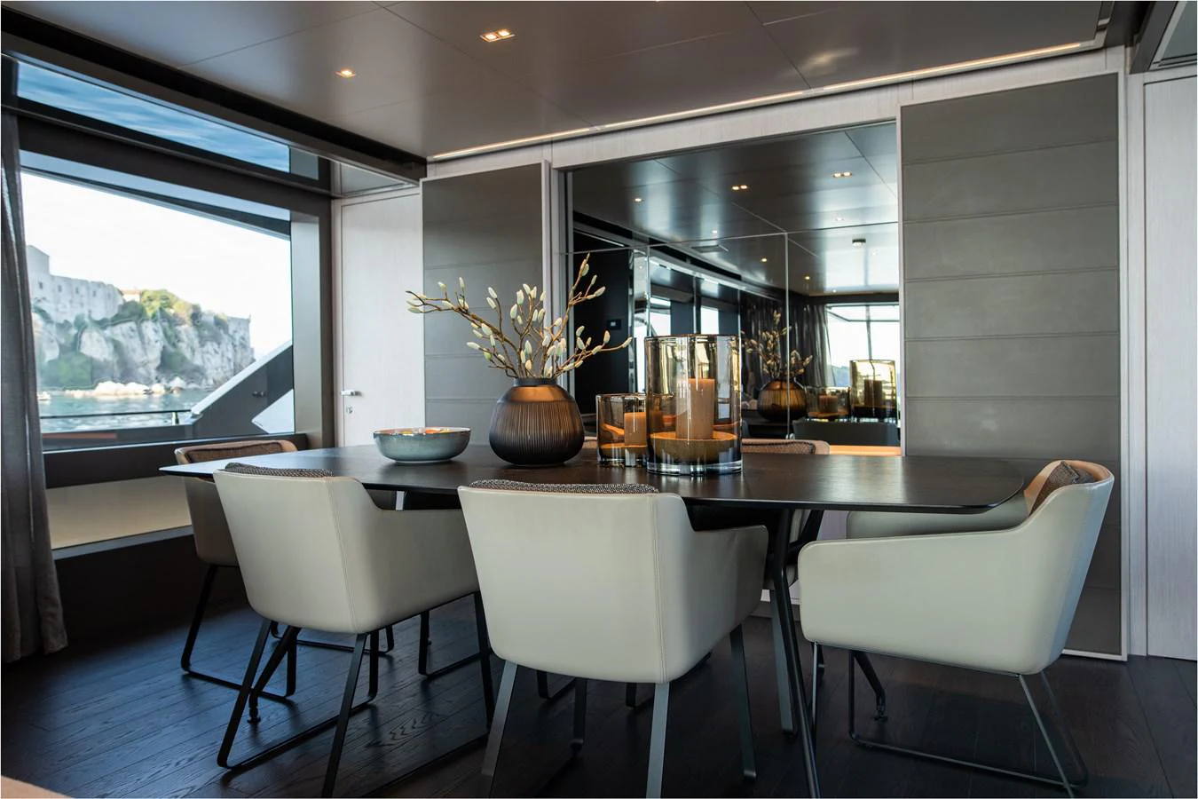 a table with chairs and a vase on it aboard O4 Yacht for Sale