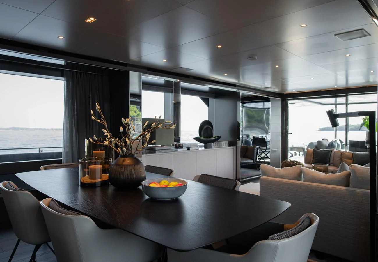 a modern looking living room with a large table and chairs aboard O4 Yacht for Sale