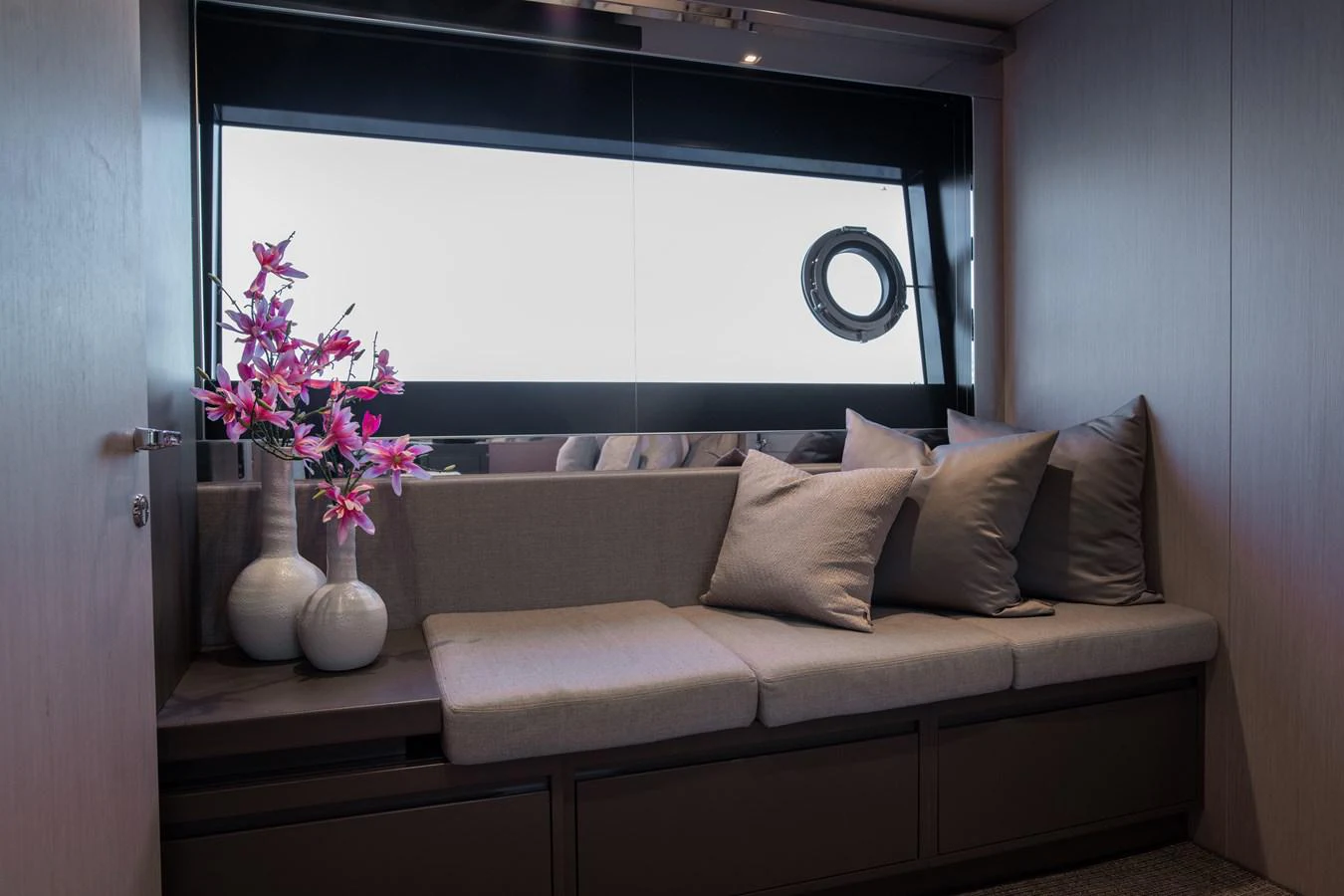 a couch with pillows and a vase of flowers on it aboard O4 Yacht for Sale