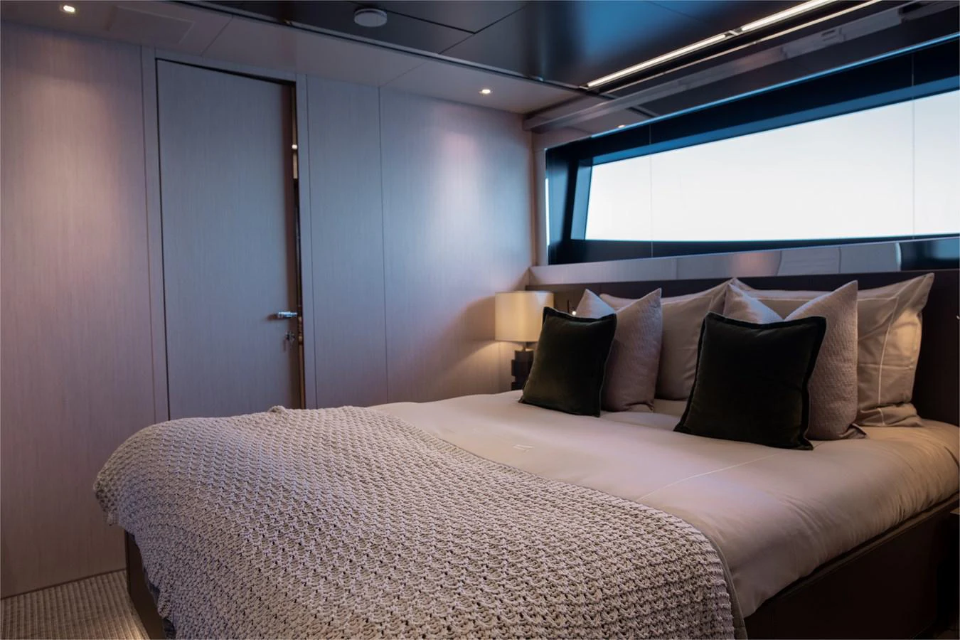 a bed with pillows on it aboard O4 Yacht for Sale