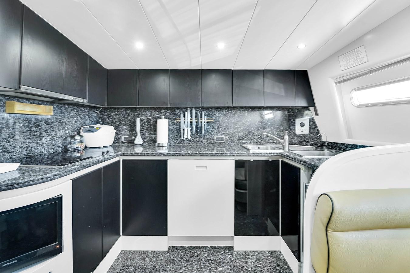 a kitchen with black cabinets aboard STAMOS BIEN Yacht for Sale