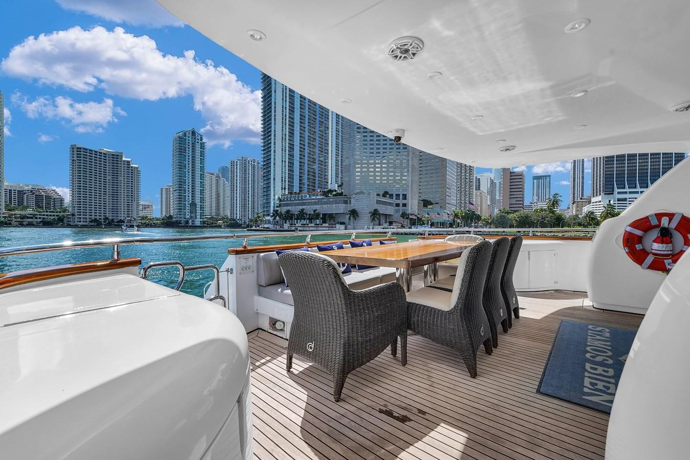 a table and chairs on a deck overlooking a city aboard STAMOS BIEN Yacht for Sale