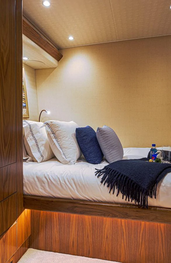 a bed with blue pillows aboard SPECULATOR Yacht for Sale
