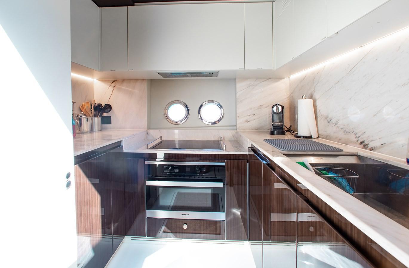 a kitchen with a stove and microwave aboard ROLLING LOUD Yacht for Sale
