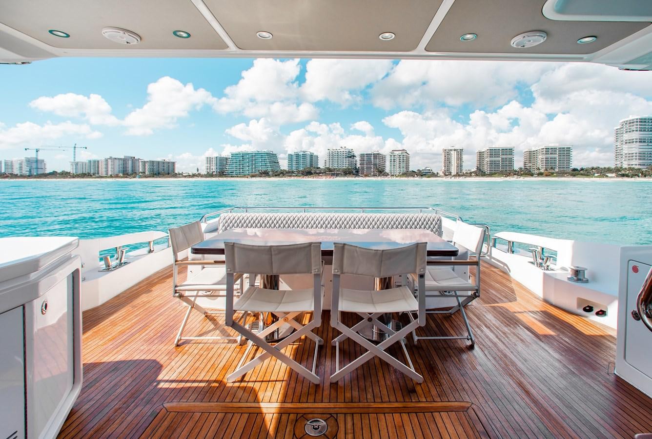 a table and chairs on a deck overlooking a city aboard ROLLING LOUD Yacht for Sale