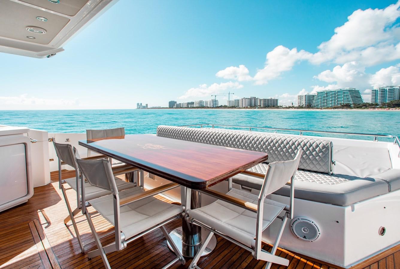 a table and chairs on a deck overlooking a body of water aboard ROLLING LOUD Yacht for Sale