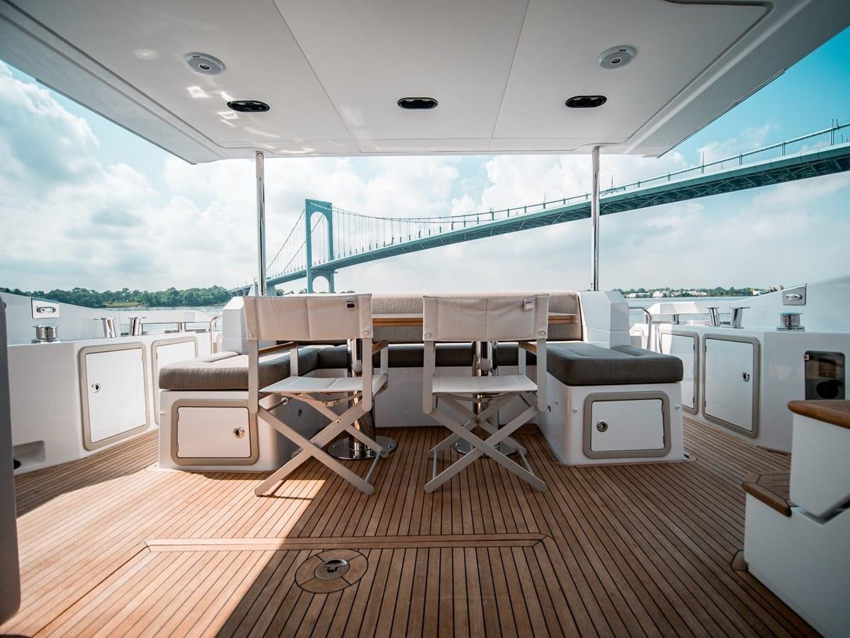 a room with a deck and chairs aboard EVADO Yacht for Sale