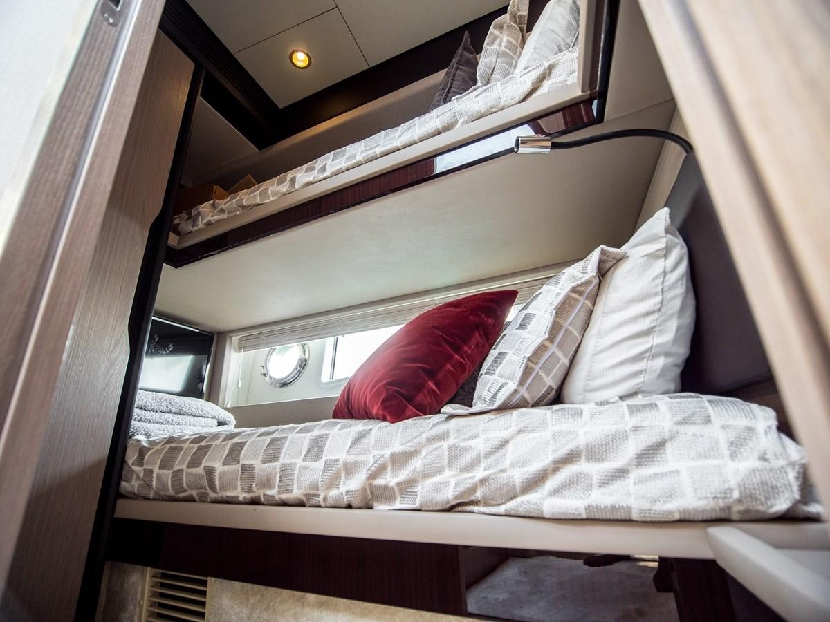 a bed with a red pillow aboard EVADO Yacht for Sale