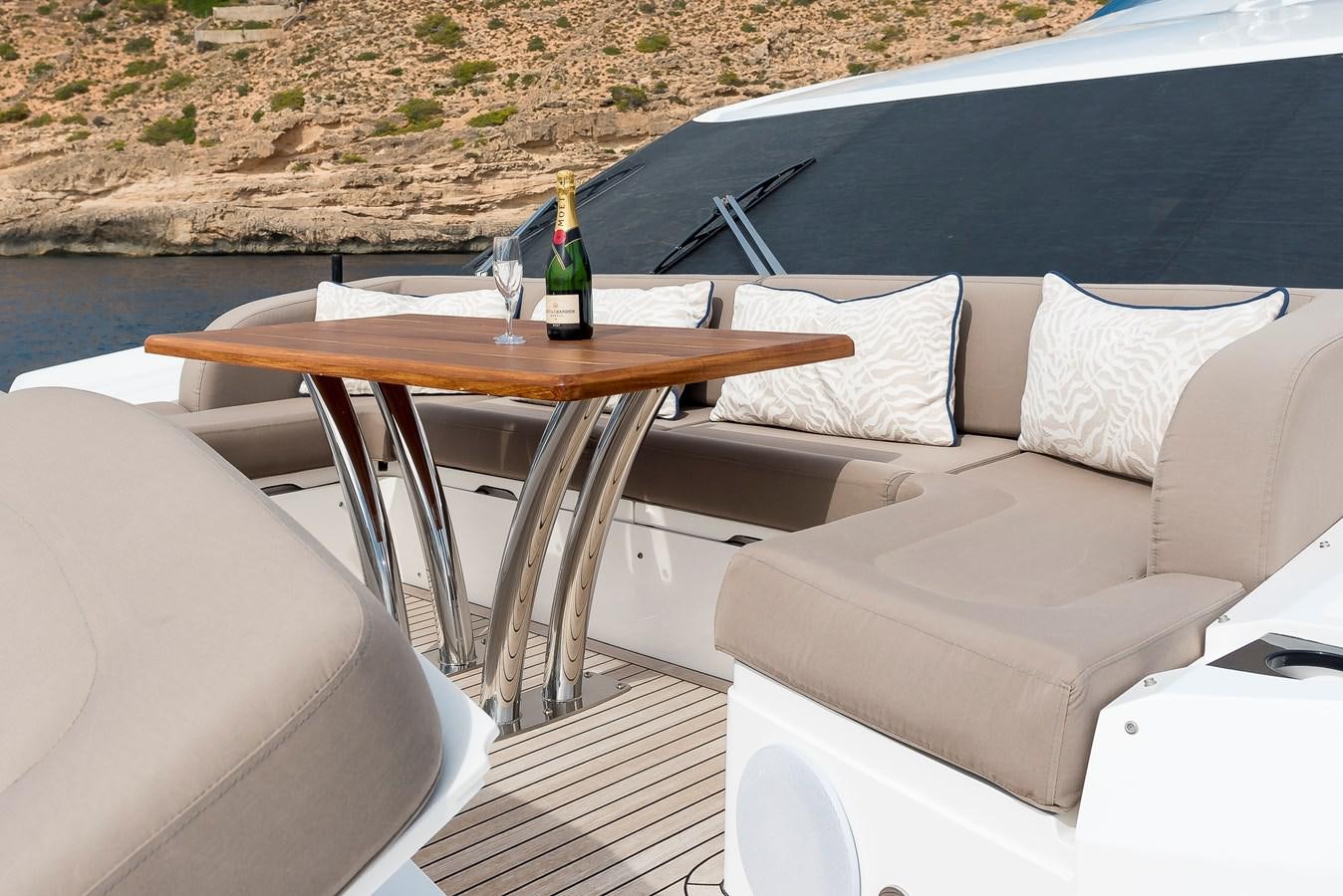 a table with chairs and a bottle on it aboard AFTER 8 II Yacht for Sale