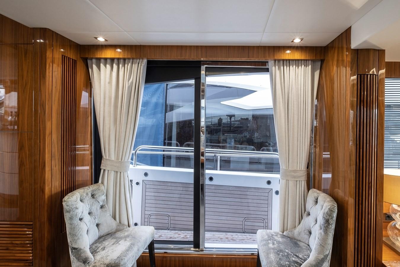 a room with a large window and a chair and a couch aboard AFTER 8 II Yacht for Sale
