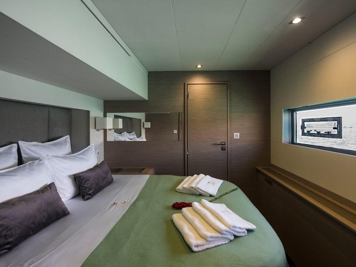 a bed with a green tablecloth aboard LISA OF THE SEAS Yacht for Sale