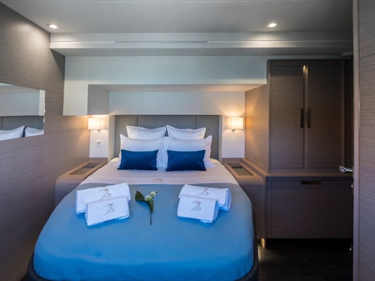 a bed with blue sheets and pillows aboard LISA OF THE SEAS Yacht for Sale