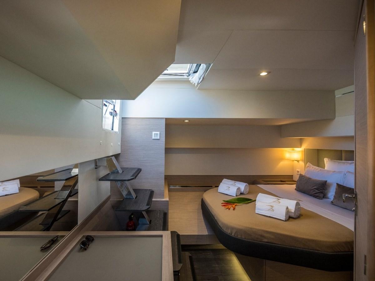 a room with a bed and desk aboard LISA OF THE SEAS Yacht for Sale