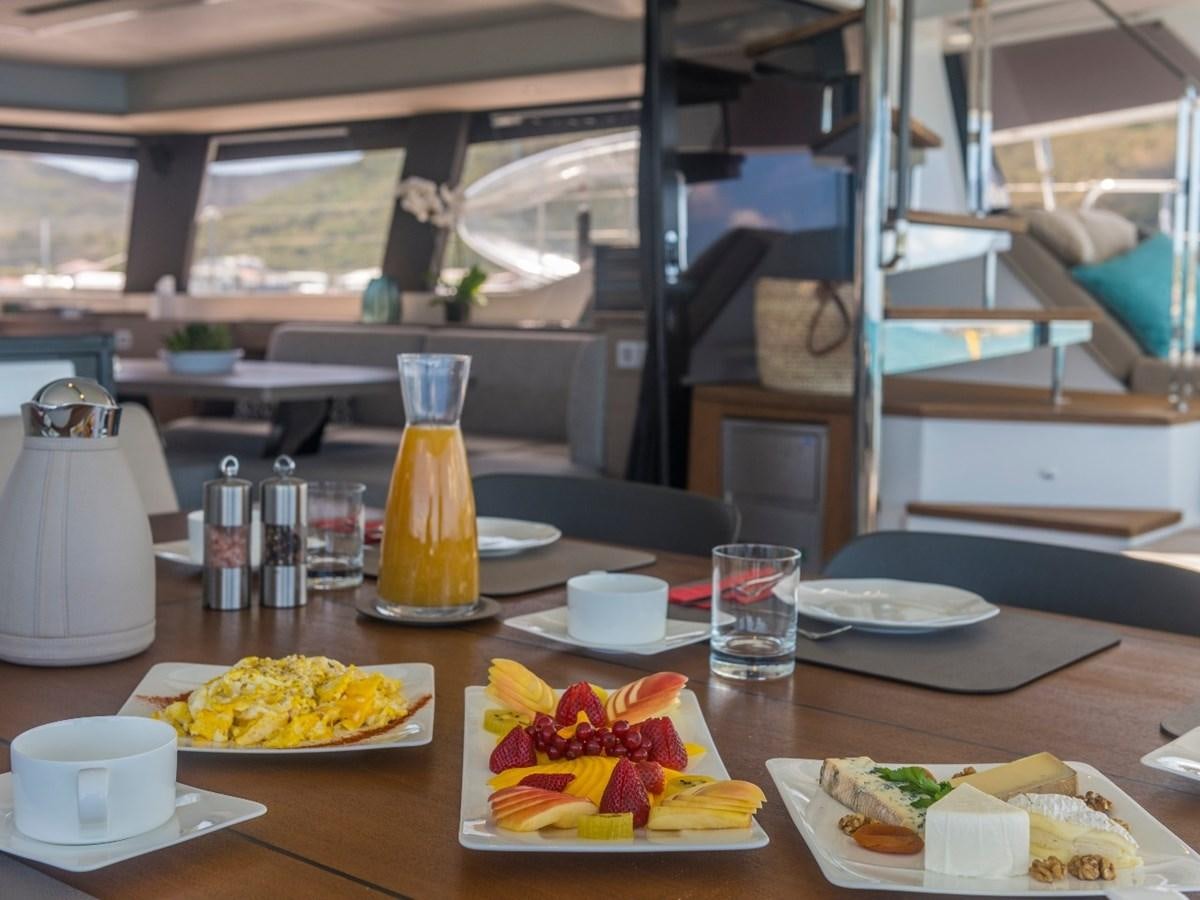 a table with plates of food and glasses on it aboard LISA OF THE SEAS Yacht for Sale