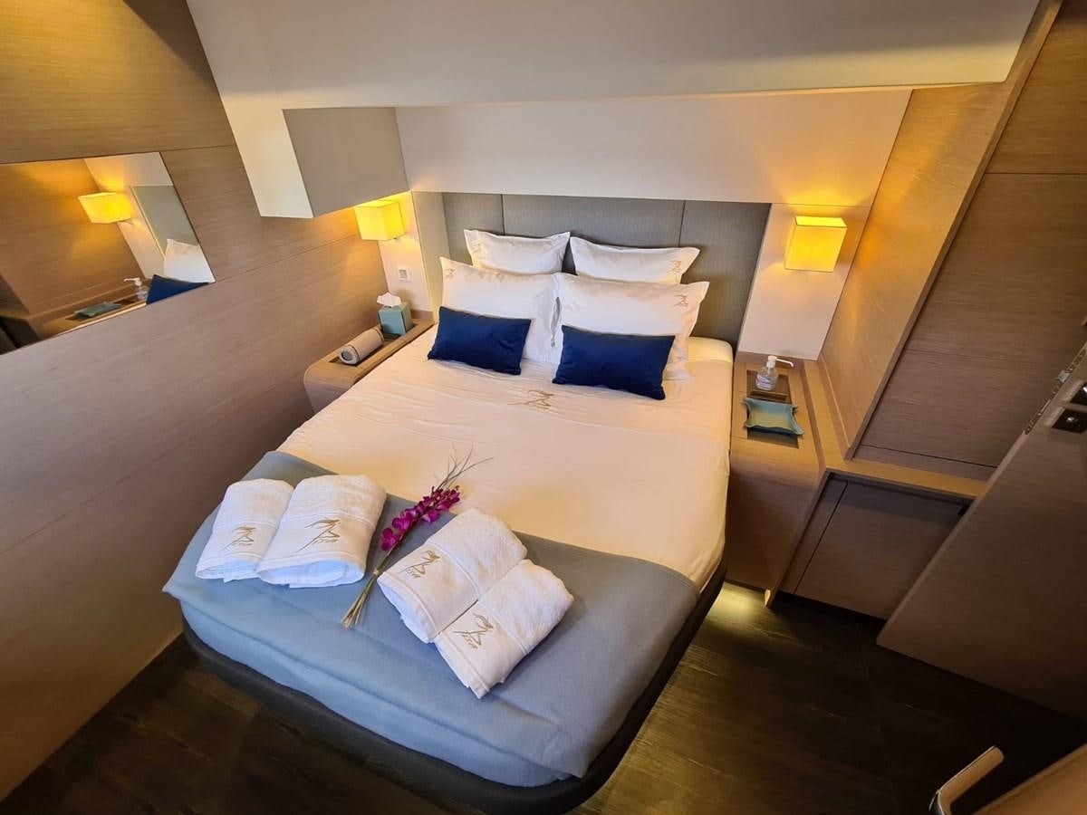 a bed with a blue and white bed spread aboard LISA OF THE SEAS Yacht for Sale