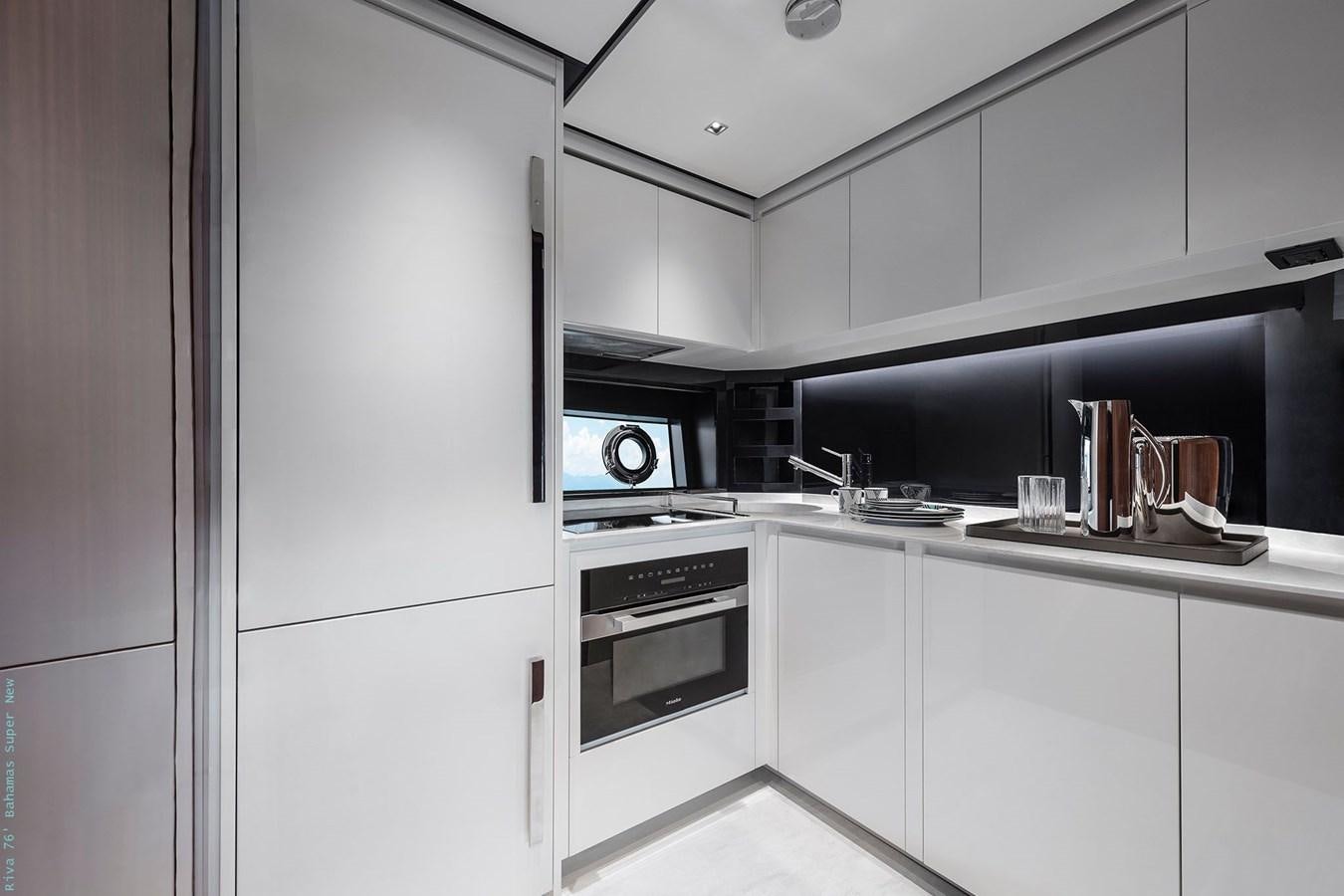 a kitchen with white cabinets aboard RIVA 76 BAHAMAS SUPER  Yacht for Sale