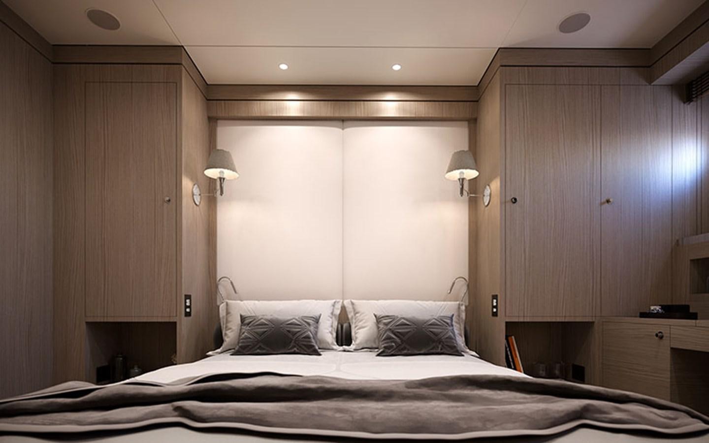 a bed with a white sheet and a wooden wall aboard AF Yacht for Sale