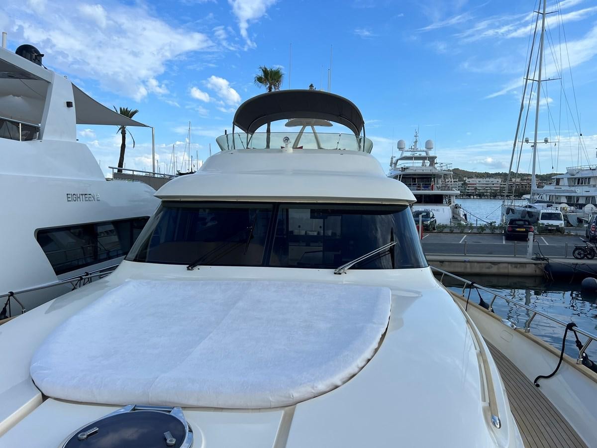 a white yacht in a harbor aboard B Yacht for Sale