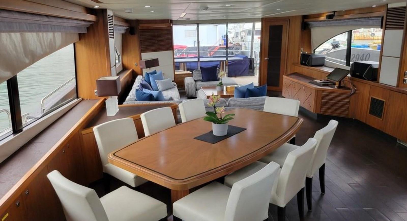 a room with a table chairs and a tv aboard AEGII Yacht for Sale