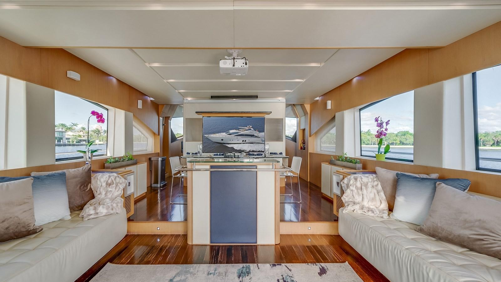 a living room with a kitchen and a large window aboard THERAPY Yacht for Sale
