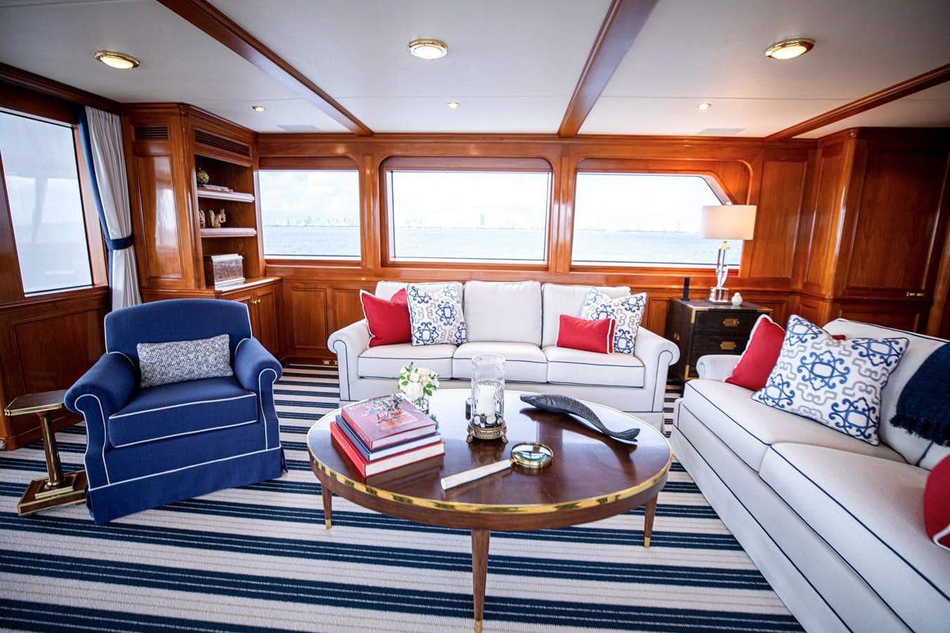 a living room with a blue chair and a white couch aboard ANJILIS Yacht for Sale