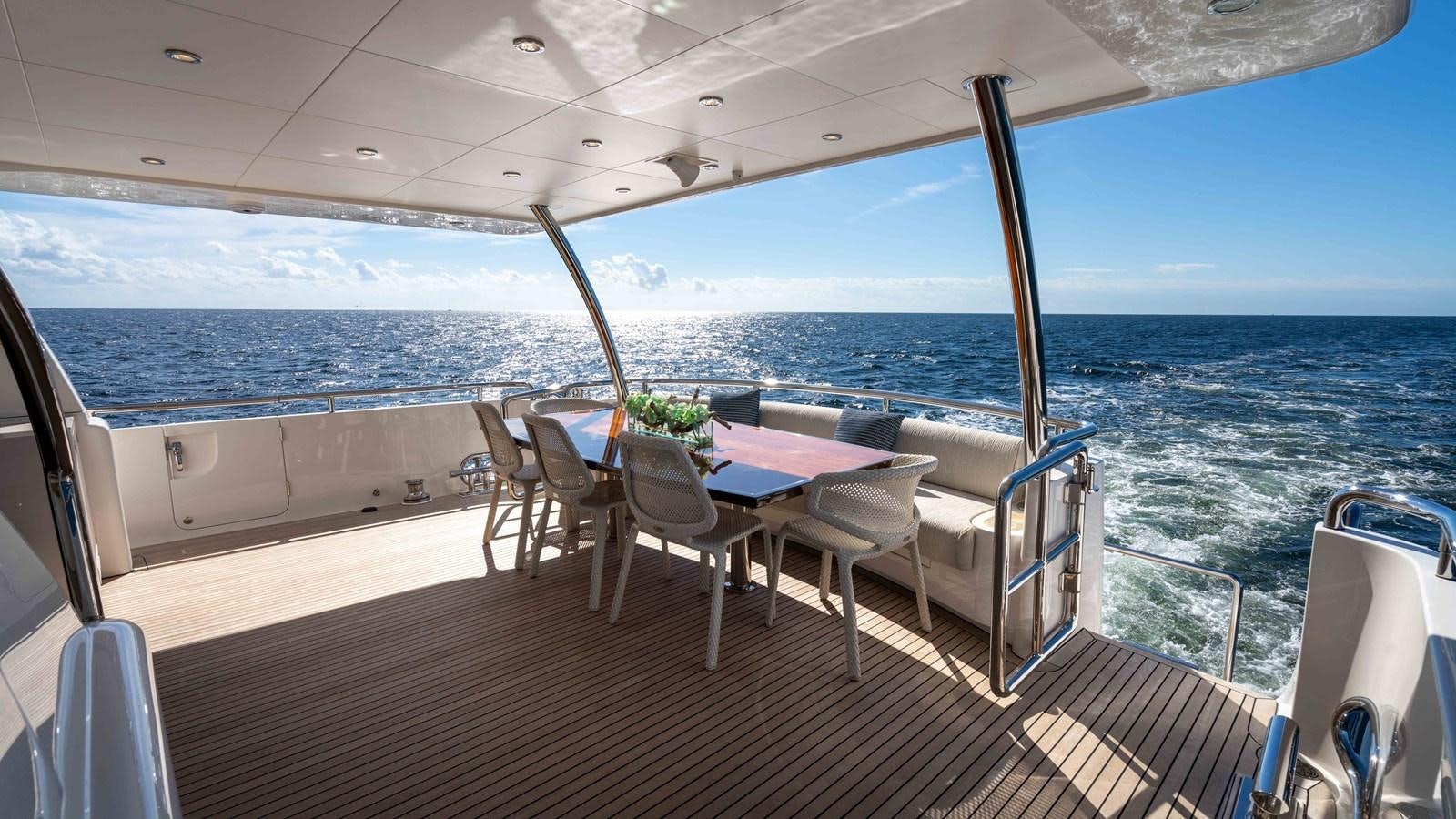 a deck with a table and chairs on it aboard SEA FAIRY Yacht for Sale