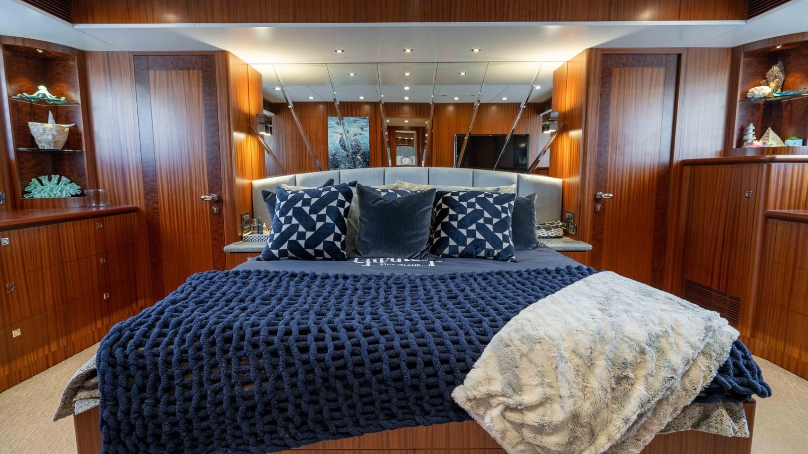 a bed with blue and white sheets aboard SEA FAIRY Yacht for Sale