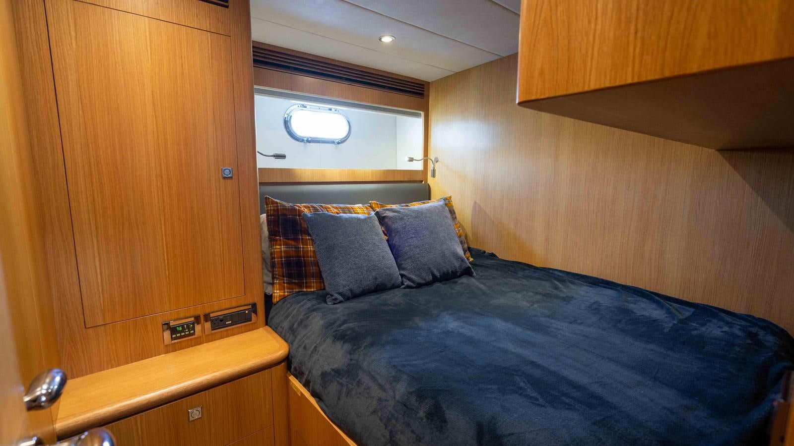 a bed with a blue comforter aboard SEA FAIRY Yacht for Sale