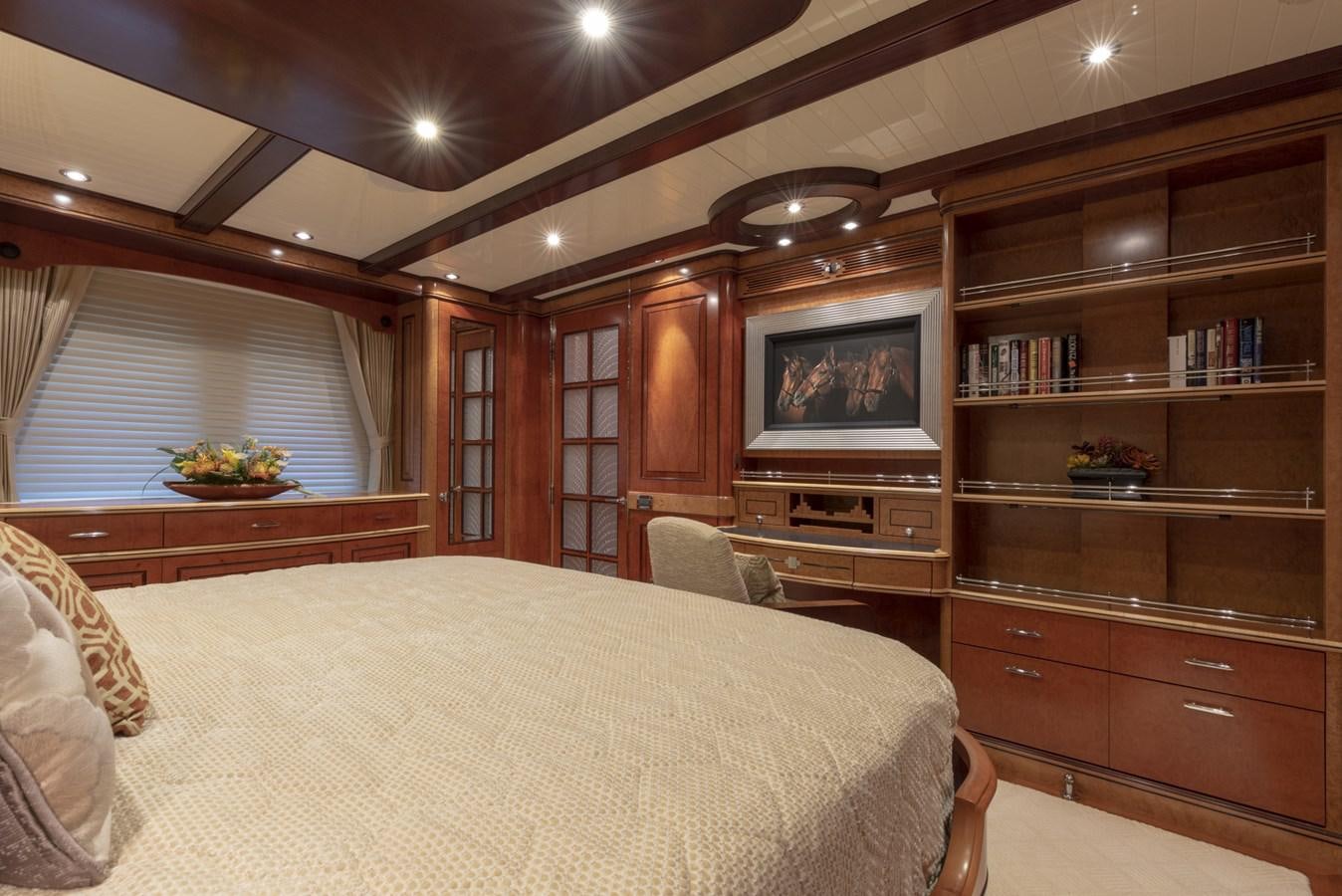 a bedroom with a bed and a bookcase aboard NADAN Yacht for Sale