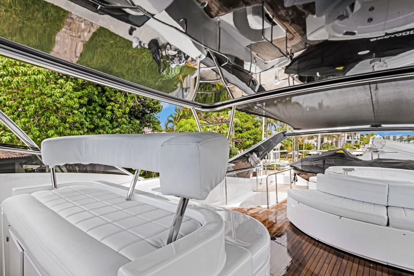 a group of white chairs on a patio with a roof and trees aboard SINPATICO Yacht for Sale